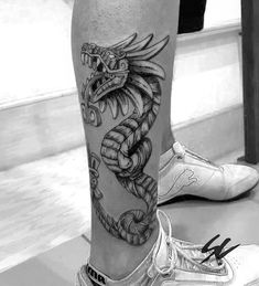 black and white photo of a man's leg with a snake tattoo on it