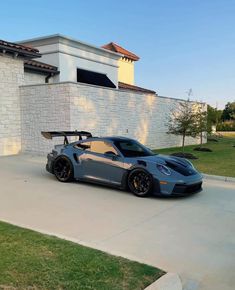 a grey sports car parked in front of a house