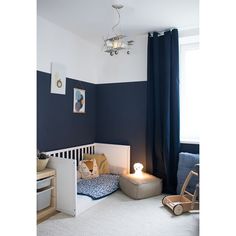 a small child's room with blue walls and white carpeting, including a crib