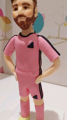 a figurine of a man with a beard wearing a pink uniform and yellow socks