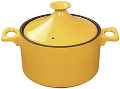 a yellow casserole with black trim on the bottom and handle is sitting in front of a white background