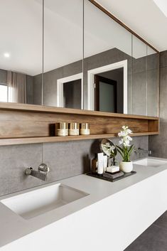 a modern bathroom with two sinks and mirrors