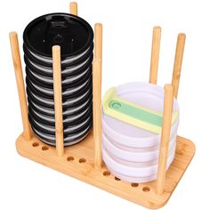 a stack of plates sitting on top of a wooden rack with bamboo sticks and bowls