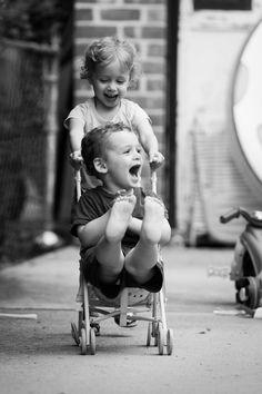 two young children sitting on top of a small child's tricycle with the words,