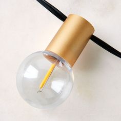 a light bulb with a pencil sticking out of it's end on a white surface