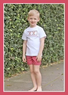 Prepare for baseball season in style with our Baseball Smocked Red Plaid Boy Short Set. The white knit shirt features smocked bats and baseballs, creating a playful and sporty look. Paired with red gingham plaid shorts, this coordinated set strikes the perfect balance between style and comfort.childrens clothing, baseball season, baseball smocking, gingham outfit, red gingham, baseball bat and ball, bubble, jon jon, short set, dress, ruffles, little girls baseball outfit, little boys baseball outfit, mlb, mlb game, mlb gameday ootd, spring training outfit, play ball, kids mlb game outfit, red baseball teams, southern sunshine, kids playwear, classic whimsy, smocked auction, Dallas Texas, online shopping, kids clothing collection, summer baseball Mlb Game Outfit, Spring Training Outfits, Girls Baseball Outfit, Training Outfit, Gingham Outfit, Girls Baseball, Summer Baseball, Baseball Teams, Dress Ruffles