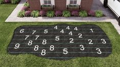 a black and white area rug with numbers on the ground in front of a house