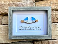 "Handmade sea glass art featuring two birds on a branch. Perfect gift for a mom and daughter living apart. Quote states \"Mother and Daughter are Never Apart, Maybe in Distance but Never in Heart\". This picture measures 5 x 7 unframed and includes a gray wood, glass front display case frame.  While you can find all of my ready-to-ship pieces of art currently on Etsy, I would be more than delighted to discuss custom projects to meet your needs. Feel free to reach out with questions at any time, I try to respond within 24hrs! Thank you so much for viewing my work! JML Relevant Tags: Mother's Day Gift Daughter Graduation  College Daughter Gift Birthday Gift Mom Inspirational Quotes Inspiring Art Inspirational Art Seaglass Art Beach Glass Art   Original Artwork Handmade Wall Decor Beach House Mother Daughter Sea Glass Art, College Daughter, Art Plage, Daughter Graduation, Personalised Gifts For Mum, Sea Glass Art Projects, Seaglass Art, Graduation College, Beach Artwork