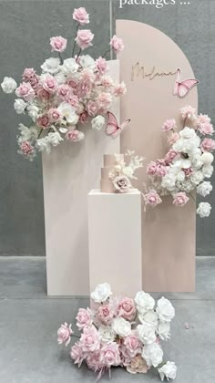 pink and white flowers in vases next to a sign