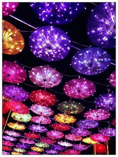 many colorful umbrellas are hanging from the ceiling