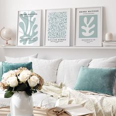 a living room filled with white furniture and flowers in a vase on top of a coffee table