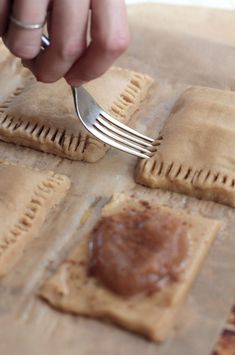 a person holding a fork over some ravioli