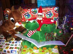 two stuffed animals are sitting next to a christmas present on a table covered with wrapping paper