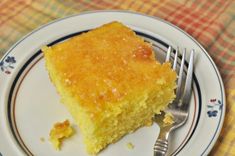 a piece of cornbread on a plate with a fork and napkin next to it