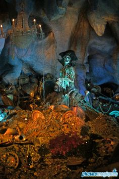 a statue in the middle of a cave filled with rocks and other things that are lit up