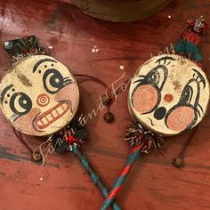 two wooden ornaments with faces painted on them