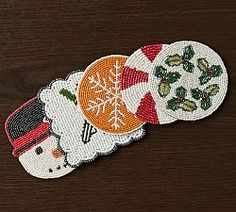 three embroidered patches with snowmen and christmas decorations on them sitting on a wooden surface