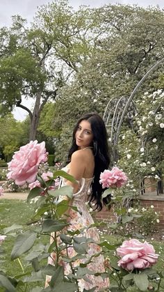 a woman standing in the middle of roses