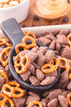 a bowl full of chocolate pretzels and some pretzels in the background