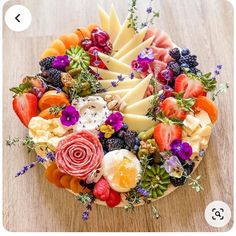 a platter filled with fruit and cheese on top of a wooden table