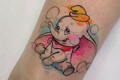 an elephant tattoo on the leg with watercolor paint splatters around it's head