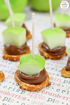 mini pretzels topped with chocolate and green apple slices on top of crackers