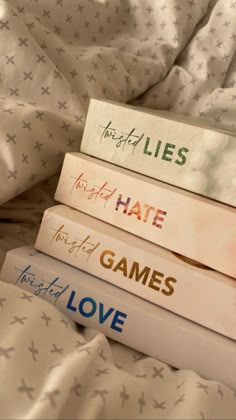 four books stacked on top of each other in front of a white bed sheet with stars