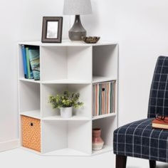 a blue chair sitting next to a white book shelf