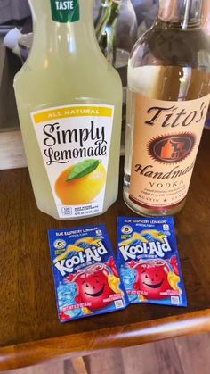 two bottles of yogurt next to each other on a wooden table with lemonade