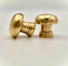 an antique brass door knob and cover on a white surface with the top part missing