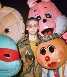 a man standing next to two giant stuffed animals and a person wearing a mask on his head