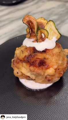 a black plate topped with food on top of a table