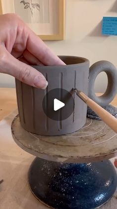 a person is painting a cup on a table