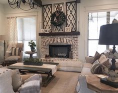 a living room filled with furniture and a fire place in front of a brick fireplace