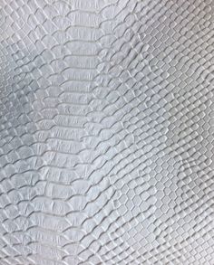 an up close view of the texture of white leather with wavy lines and ridges on it