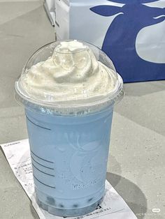 a blue drink with whipped cream on top