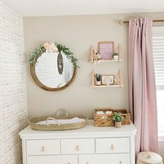 a baby's room with a dresser, mirror and toys on the shelf in front of it