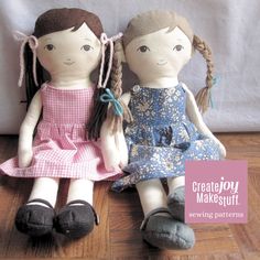 two dolls sitting next to each other on a wooden floor