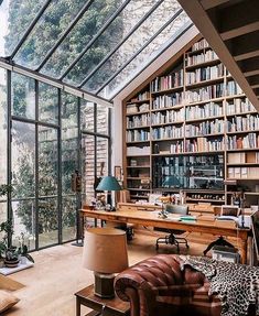 a living room filled with lots of furniture and bookshelves covered in glass walls