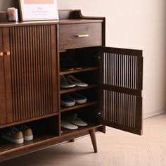 a wooden cabinet with shoes inside of it