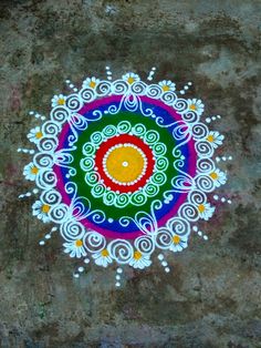 an artistic painting on the ground with white and yellow circles around it, painted in bright colors