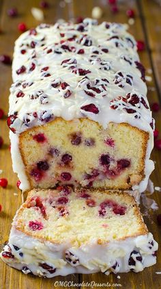 a loaf of cranberry pound cake with white frosting and fresh cherries