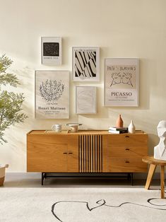 a living room with art on the wall and a wooden cabinet in front of it