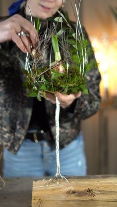 a woman is holding some plants in her hands