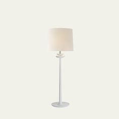 a white floor lamp with a light on it's side and a round shade