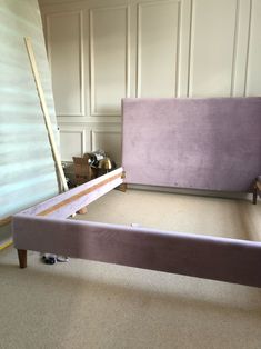 a purple bed frame in a room with white walls