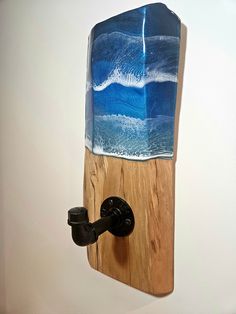 a wooden board mounted to the wall with a blue and white surfboard on it