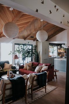 a living room filled with furniture and lots of lights hanging from the rafter ceiling