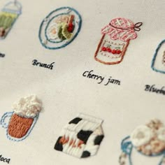 embroidered labels on fabric with different types of food and drink items in the center, including milkshake, strawberry jam, blueberry jam, banana, orange juice, and more