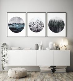 three black and white paintings on the wall above a dresser